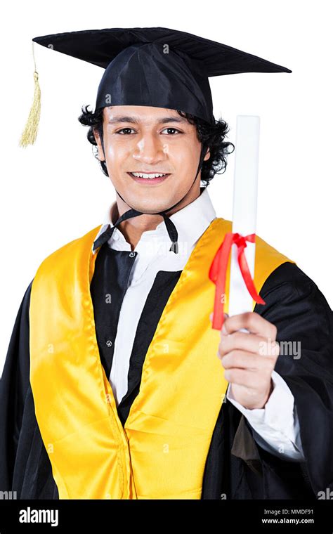 Close Up Of Boy In Graduation Gown Holding Diploma Hi Res Stock