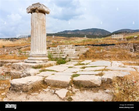 Ancient Ruined Classical Doric Column And Flagstones In Rural Greek