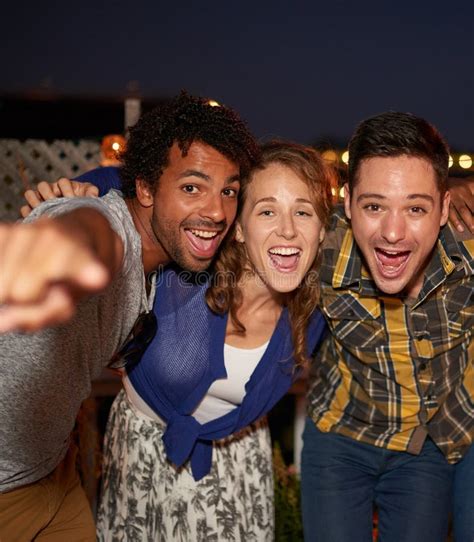 Multi Ethnic Millenial Friends Taking A Flash Selfie With Mobile Phone On Rooftop Patio Stock