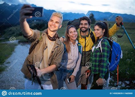 Group Of Friends Resting On Mountain While Hiking Hikers Relaxing And