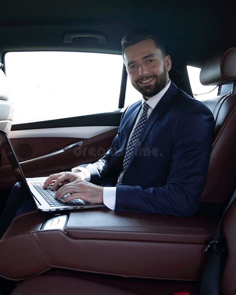 Smiling Businessman Sitting In The Back Seat Of A Prestigious Car Stock