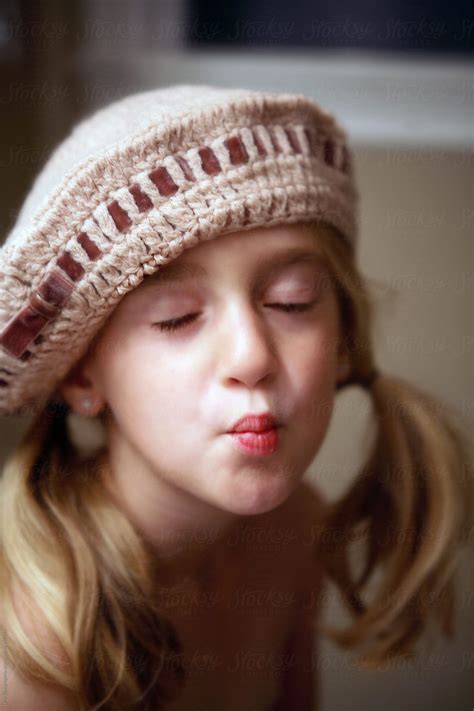 Girl In Knitted Hat Making Kissy Face By Stocksy Contributor Dina