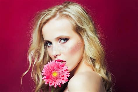 Closeup Afce Portrait Of Beautiful Passionate Blonde Woman Holding Gerbera Flower Near Face