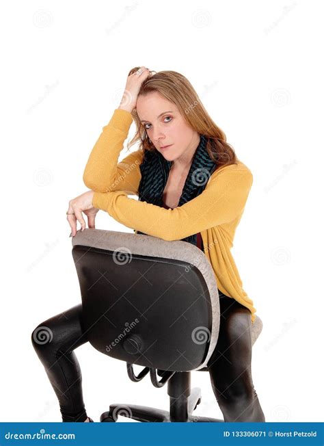 A Serious Looking Woman Sitting Backwards On Office Chair Stock Image