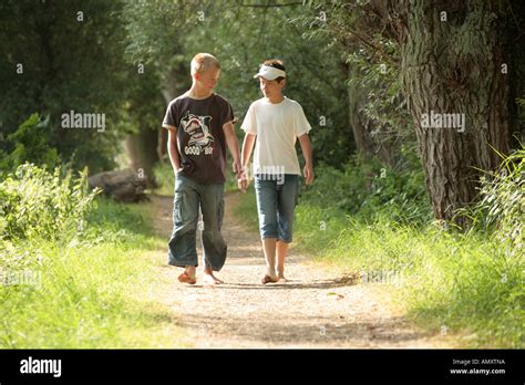 Two Boys Walking Barefoot Through The Woods Stock Photo Alamy