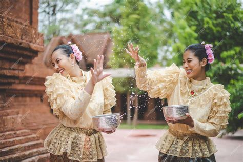 Premium Photo Young Smiling Women Dress In Beautiful Thai Costumes Splashing Water In Temples