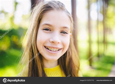 linda adolescente con frenos sonriendo alegremente vestida con ropa color fotografía de stock