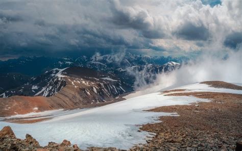 Premium Photo Giant Mountains With Snow Above White Clouds In Sunny