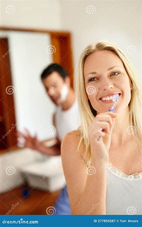 Enjoying Each Others Company Before Going To Work A Happy Woman Brushing Her Teeth While Her