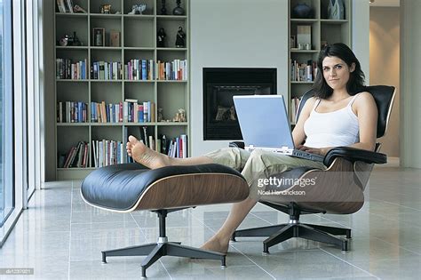 Woman Sitting On A Swivel Chair With Her Feet Up On A Footrest And