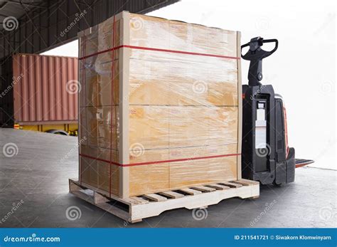 Stacked Of Package Boxes On Pallet Rack And Forklift Pallet Jack Waiting To Load Into Shipping