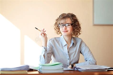 Teacher Sit At The Desk In The Classroom And Check Notebook Stock Image Image Of Spectacles