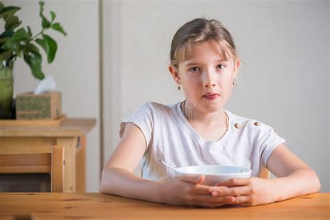 Blonde Teenage Girl Eating Cereal For Breakfast Lifestyle Portrait