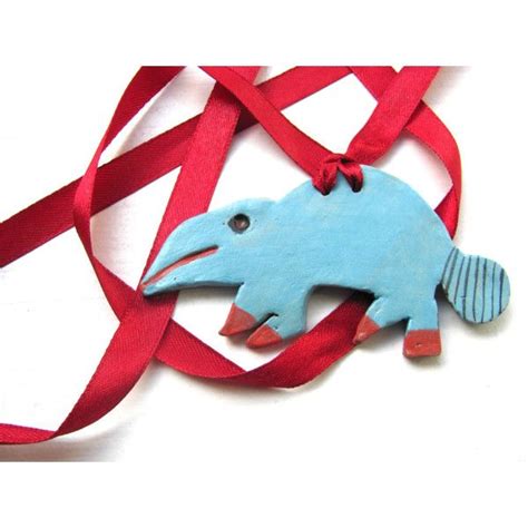 A Blue Fish Ornament Hanging From A Red Ribbon