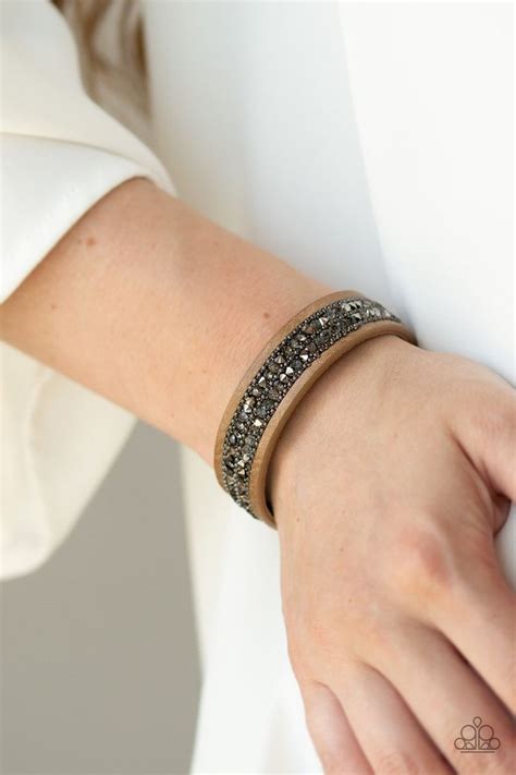 The Center Of A Skinny Brown Leather Band Is Encrusted In Alternating