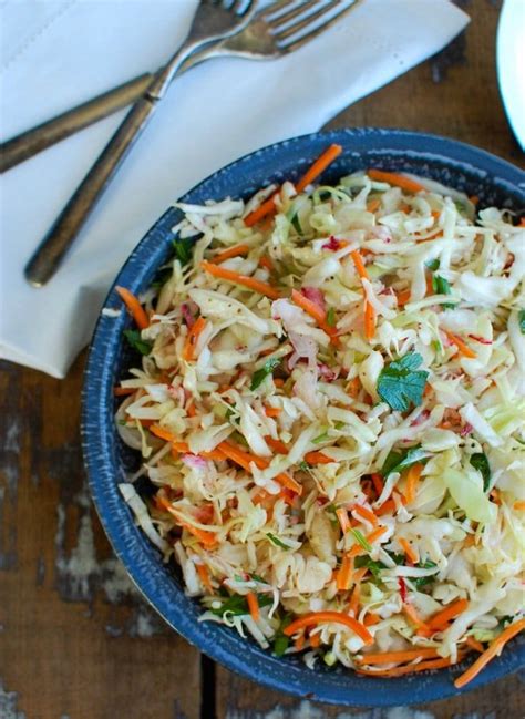 A Blue Bowl Filled With Coleslaw And Carrots