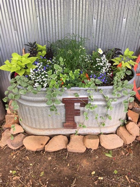 A Metal Planter Filled With Flowers And Plants
