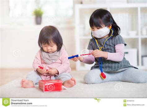 Two Happy Japanese Sisters Playing With Medical Set At Home Stock