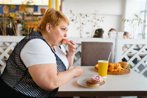 Fat Woman Eating Doughnuts In Fastfood Restaurant Stock Photo By NomadSoul