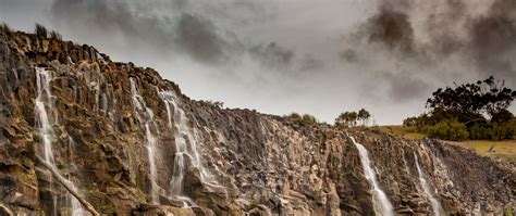 Download Wallpaper 2560x1080 Waterfall Rocks Cliff Trees Stones