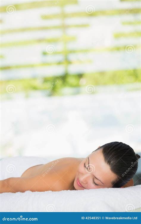 Smiling Brunette Lying On Massage Table With Eyes Closed Stock Image