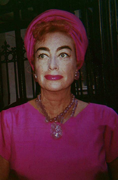 An Older Woman Wearing A Pink Dress And Pearls On Her Necklace Is