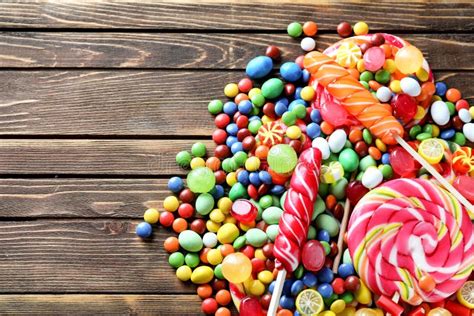 Delicious Candies With Lollipops On Wooden Background Stock Photo
