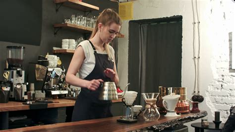 Young Female Barista In Trendy Modern Cafe Coffee Shop Pours Boiling