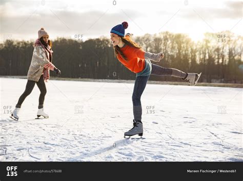 Two Women Ice Skating On Frozen Lake Stock Photo Offset