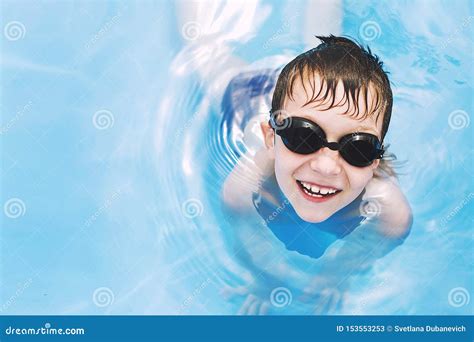 Bambino Felice Nel Raggruppamento Nuotate Del Ragazzo Nello Stagno Con I Vetri Di Nuoto Immagine