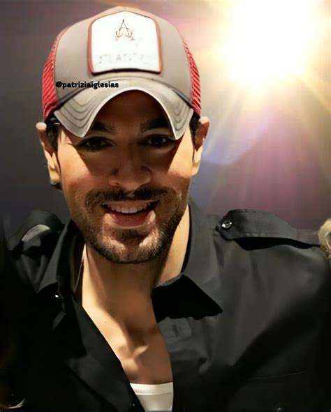 A Man Wearing A Hat And Smiling At The Camera With Bright Light Behind