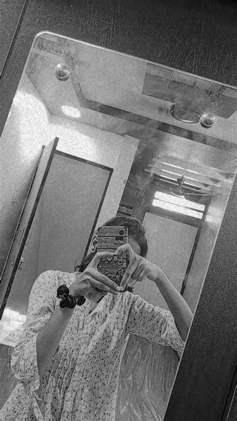 a woman taking a selfie in front of a mirror