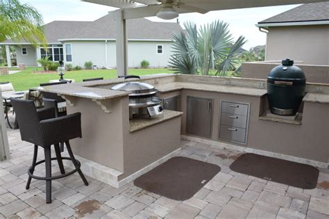 The outdoor kitchen design selects the big green egg beside the stove that lies next to the sink unit. Outdoor Kitchen with pergola, knee wall, Big Green Egg and ...