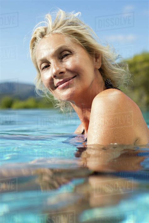 Mature Woman Relaxing In Pool Portrait Stock Photo Dissolve