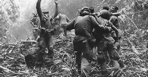 As Fellow Troopers Aid Wounded Colleagues A Paratrooper Of A Company 101st Airborne Guides A