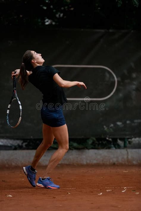Close Up View Of Active Female Tennis Player With Tennis Racket In Her Hand Behind Her Back