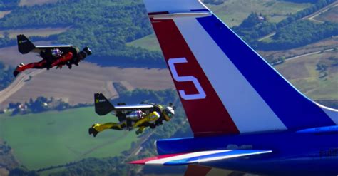 Three Men Use Jet Packs To Fly In Formation With Real Jets