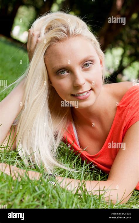Beautiful Young Blonde Girl Lying In Grass Summertime Outdoor In Park