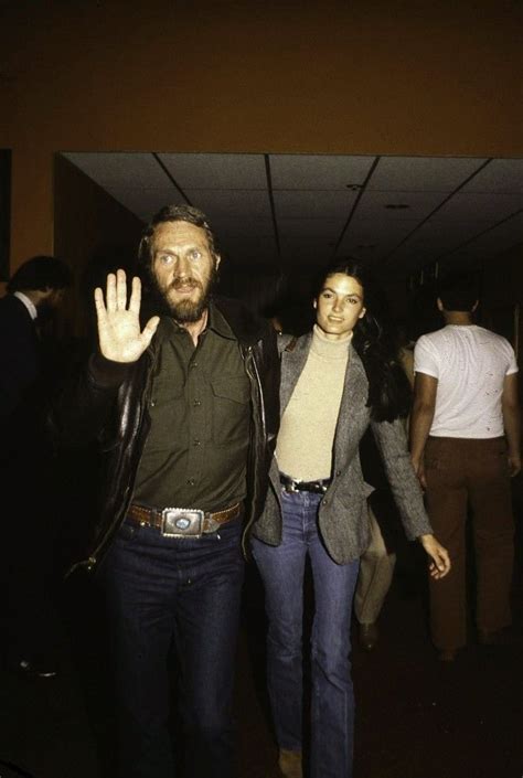 A Man And Woman Are Walking Down The Hall With Their Hand Up In The Air