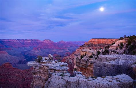 Grand Canyon With Moon At Purple Sunset Stock Photo