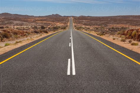 Long Straight Desert Highway Road Stretching Into The Distance By