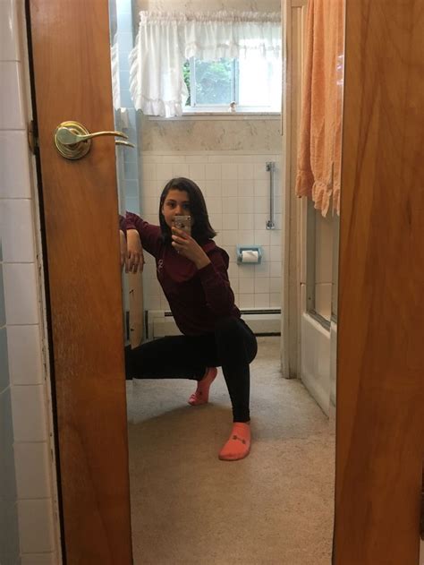 A Woman Is Taking A Selfie In The Bathroom While Sitting On The Floor