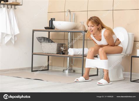 Woman Suffering From Diarrhea While Sitting On Toilet Bowl At Home Stock Photo By Serezniy