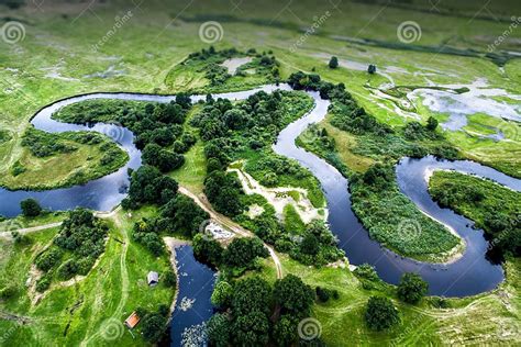 Top View Of The Valley Of A Meandering River Among Green Fields Stock