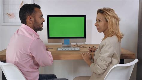 Business People Sitting At The Desk In Front Of Computer With Green Screen Have Conversation