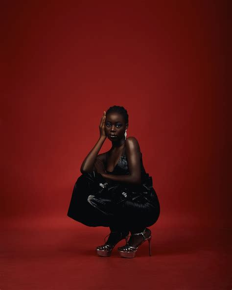 a woman in a black dress kneeling on a red background photo free fashion image on unsplash