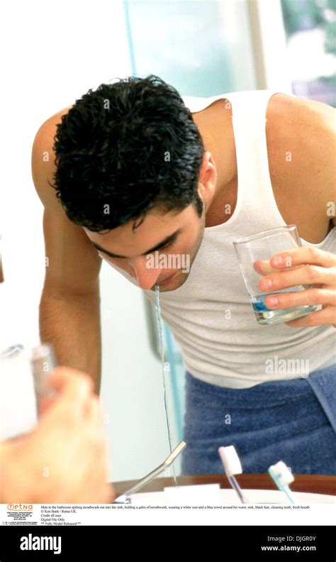 Man In The Bathroom Spitting Mouthwash Out Into The Sink Hi Res Stock