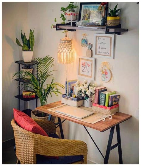 A Desk With Some Plants And Pictures On The Wall Above It Along With