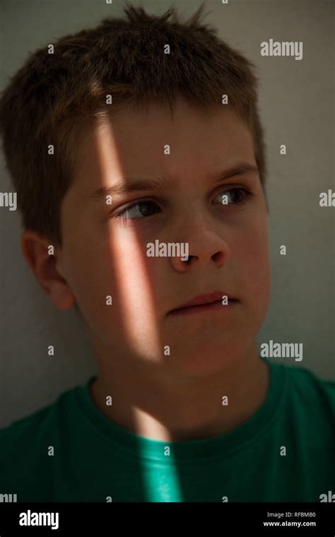 Shaft Of Light On The Face Of A 7 Year Old Boy With Short Brown Hair
