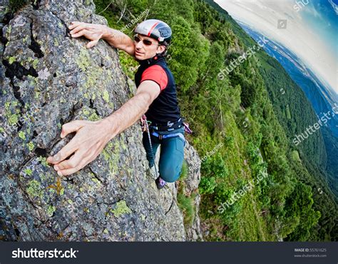 Young White Man Climbing A Steep Wall In Mountain Rock Climb Extreme